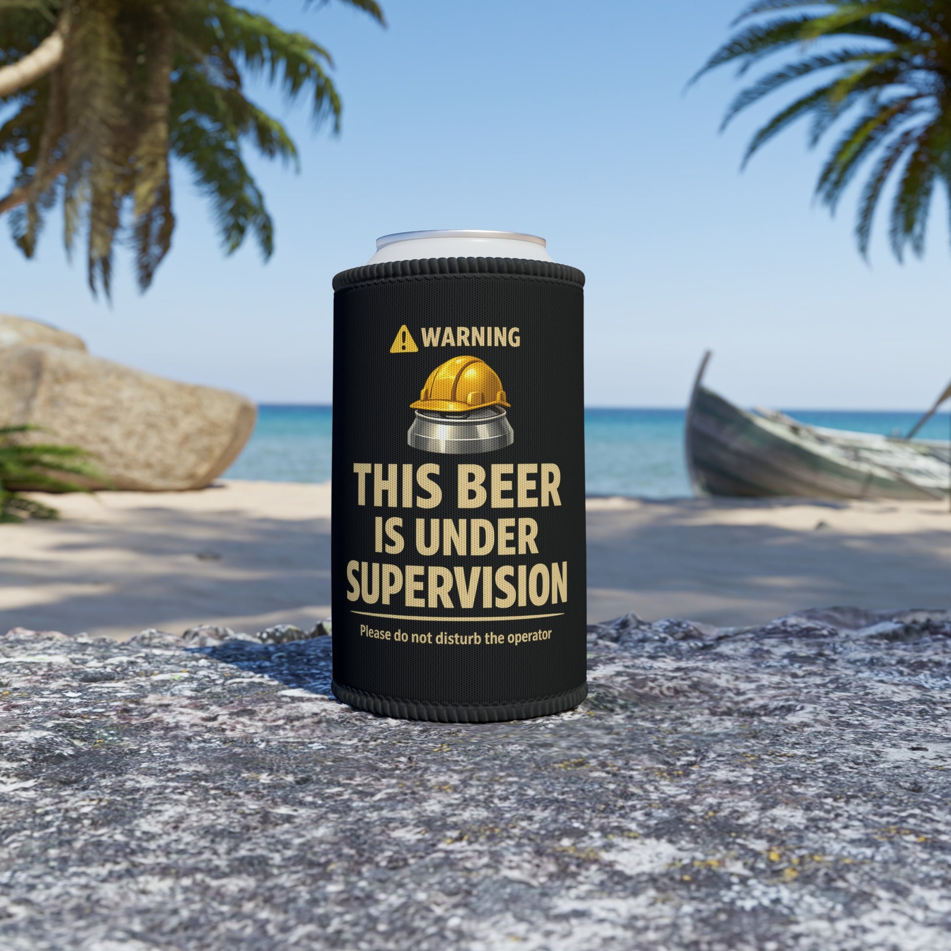 Black can holderwith 'This beer is under supervision' text on a beach.